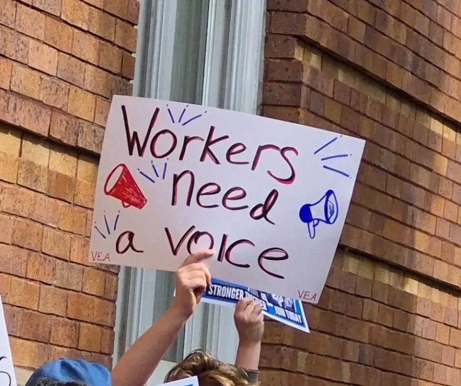 Worker holding a sign that says "Workers need a voice"